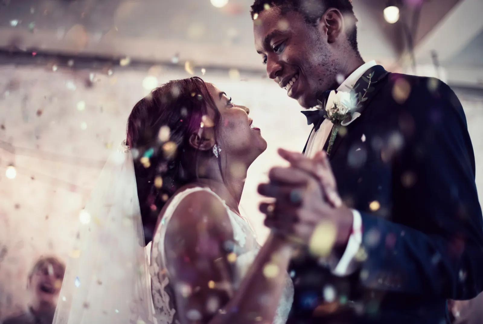 Bride and groom dancing under confetti at their wedding
