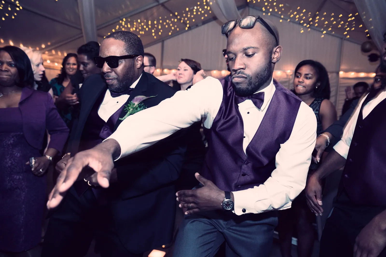 Wedding guests dancing under coloured lights on a packed dance floor
